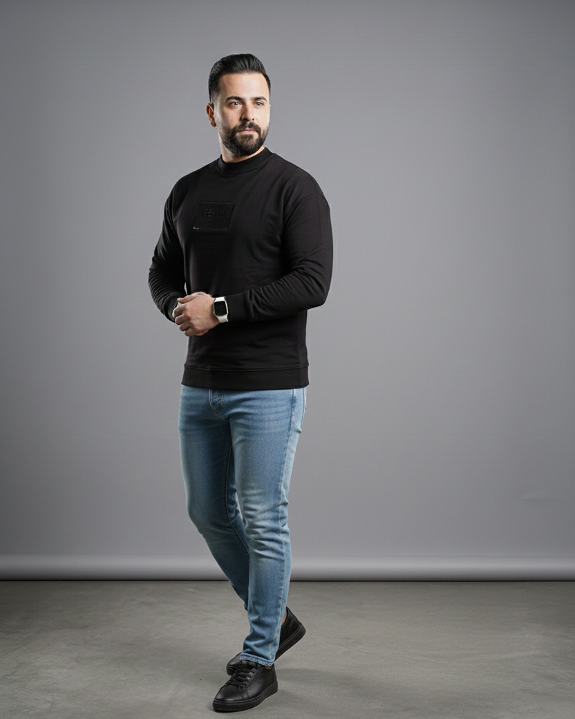 Man wearing a black sweater and blue jeans standing against a gray background with 'Available on Shopify' text.